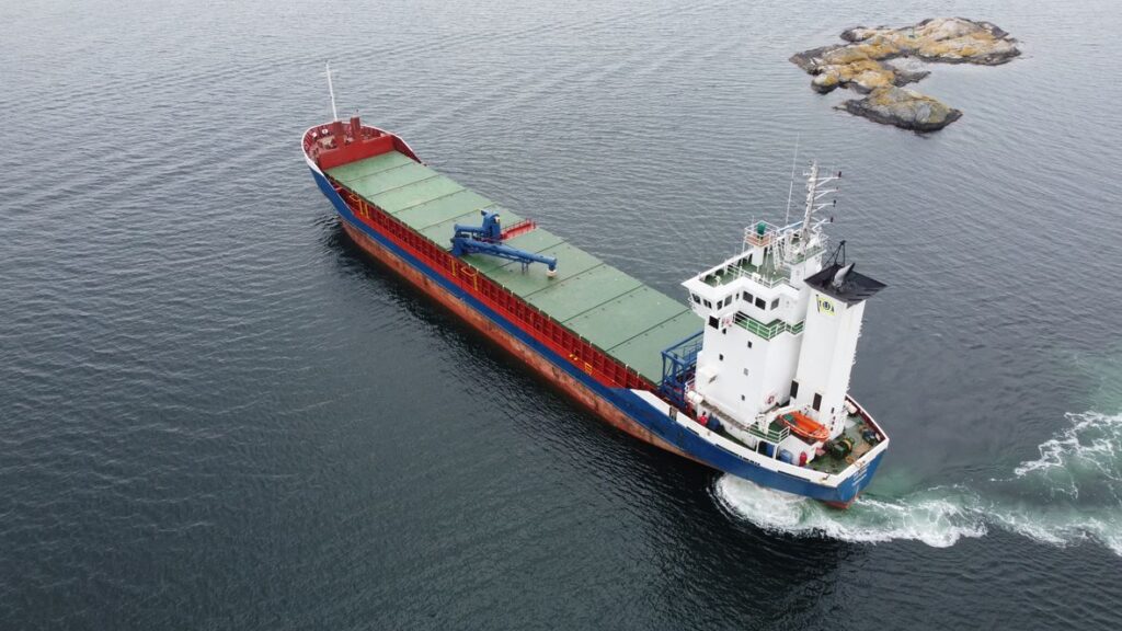 The vessel under way past skerries, seen from the air