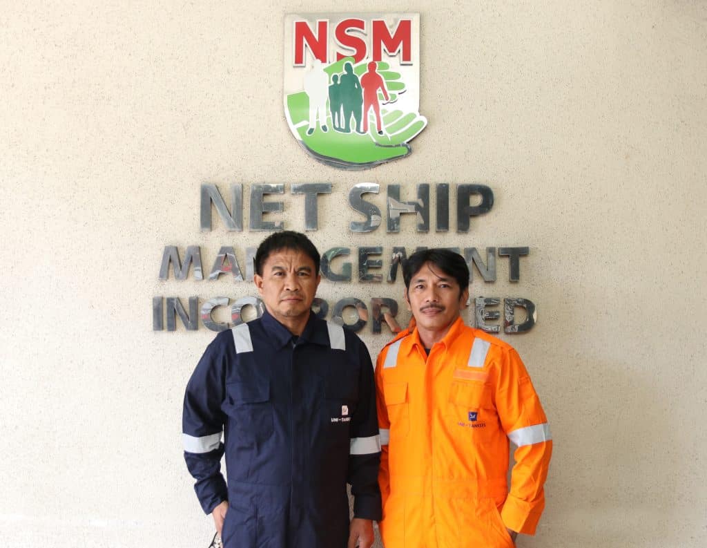 Two crew members outside the Net Ship Management office