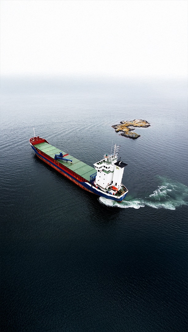 Self-unloader seen from above, passing a skerry